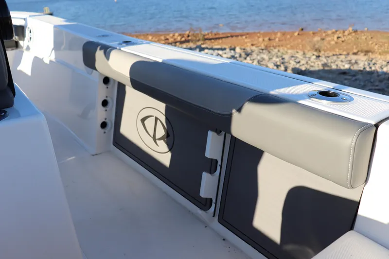 Slide: The Image of 2024 Sea Born LX22 Center Console boat interior with cushioned seating by the water. - 15