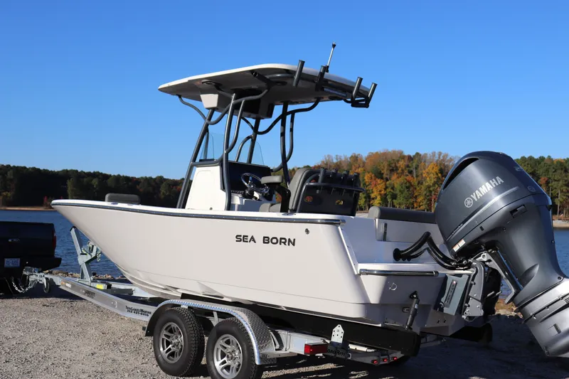 Slide: The Image of 2024 Sea Born LX22 Center Console boat on trailer by a lake. - 16