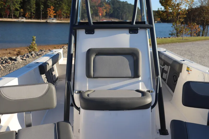 Slide: The Image of 2024 Sea Born LX22 Center Console boat interior with seating, near a scenic lake. - 5