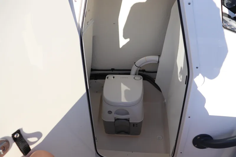 Slide: The Image of 2024 Sea Born LX22 Center Console boat interior with compact marine toilet. - 7