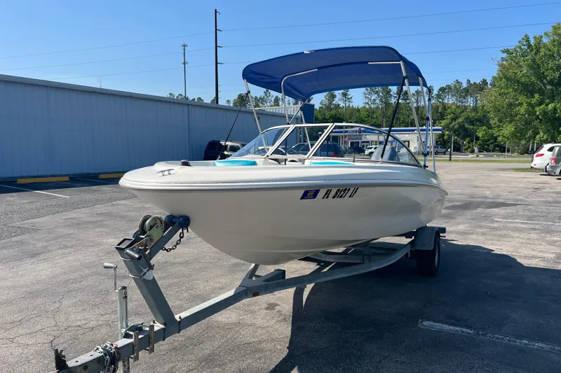 Slide: The Image of 2000 Wellcraft Capri boat on trailer with blue canopy in parking lot. - 10