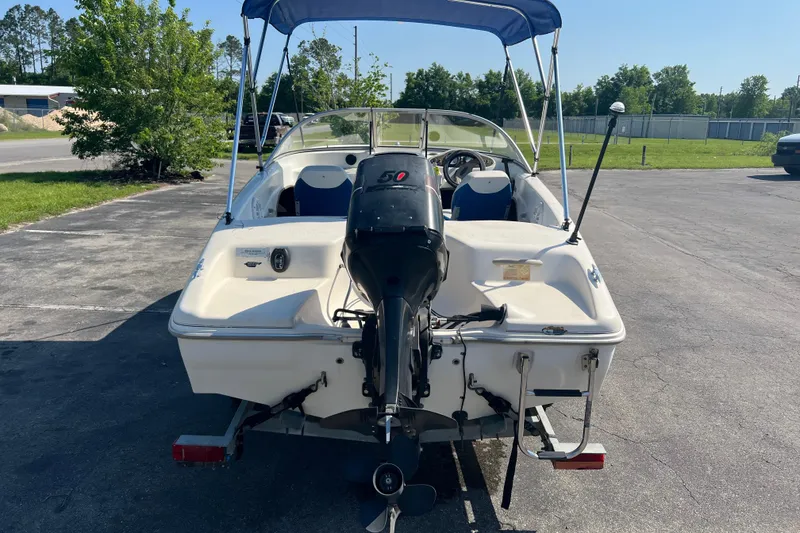 Slide: The Image of 2000 Wellcraft Capri boat with outboard motor and canopy, parked on pavement. - 15