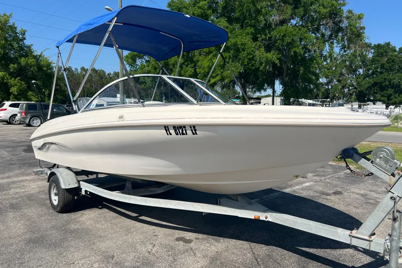 Slide: The Image of 2000 Wellcraft Capri boat on trailer with blue canopy in sunny outdoor setting. - 3