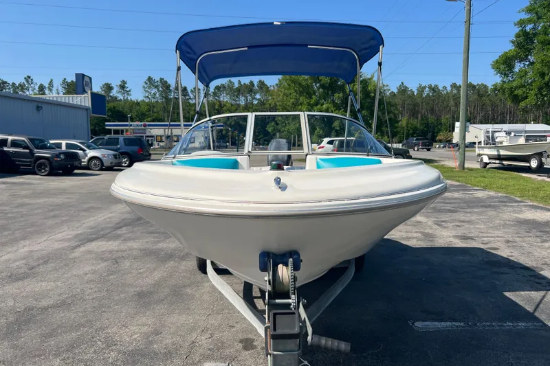 Slide: The Image of 2000 Wellcraft Capri boat with blue canopy on trailer in parking lot. - 6