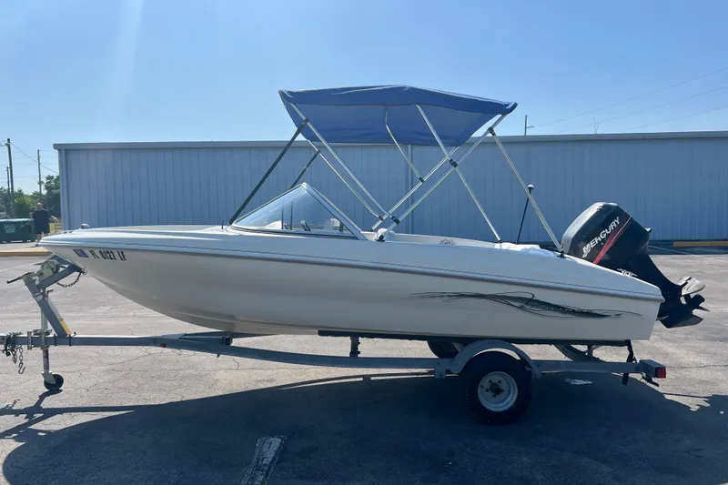 Slide: The Image of 2000 Wellcraft Capri boat on trailer with blue canopy and Mercury outboard motor. - 9
