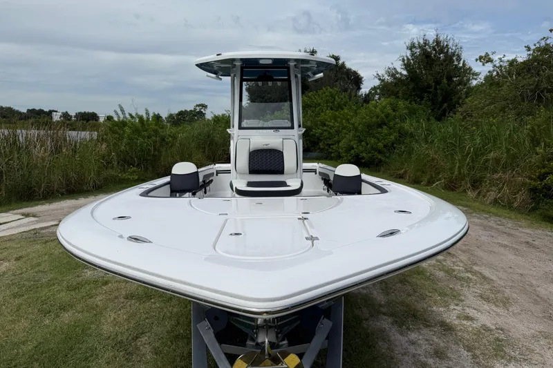 Slide: The Image of 2026 Tidewater 2700 Carolina Bay boat on grassy terrain, surrounded by lush greenery. - 12