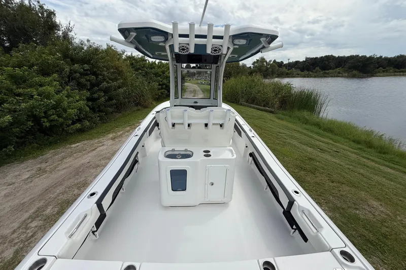 Slide: The Image of 2026 Tidewater 2700 Carolina Bay boat, spacious deck, near lush greenery and water. - 14