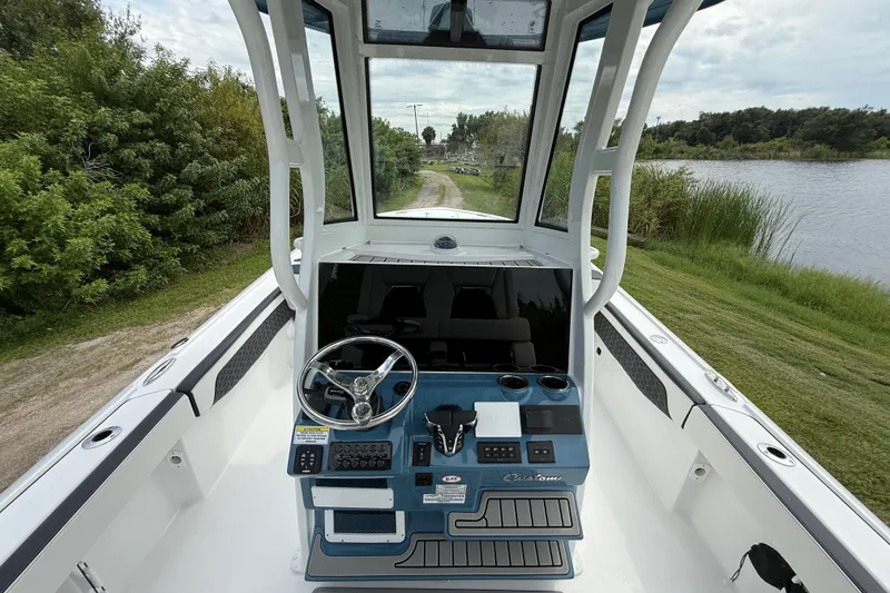 Slide: The Image of 2026 Tidewater 2700 Carolina Bay boat interior with steering console, near a scenic waterway. - 16