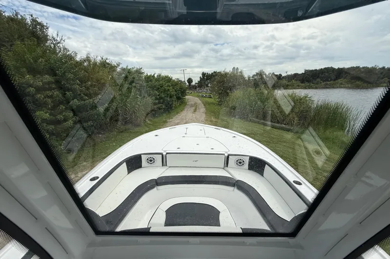 Slide: The Image of 2026 Tidewater 2700 Carolina Bay boat on a scenic lakeside path, viewed from the interior. - 17