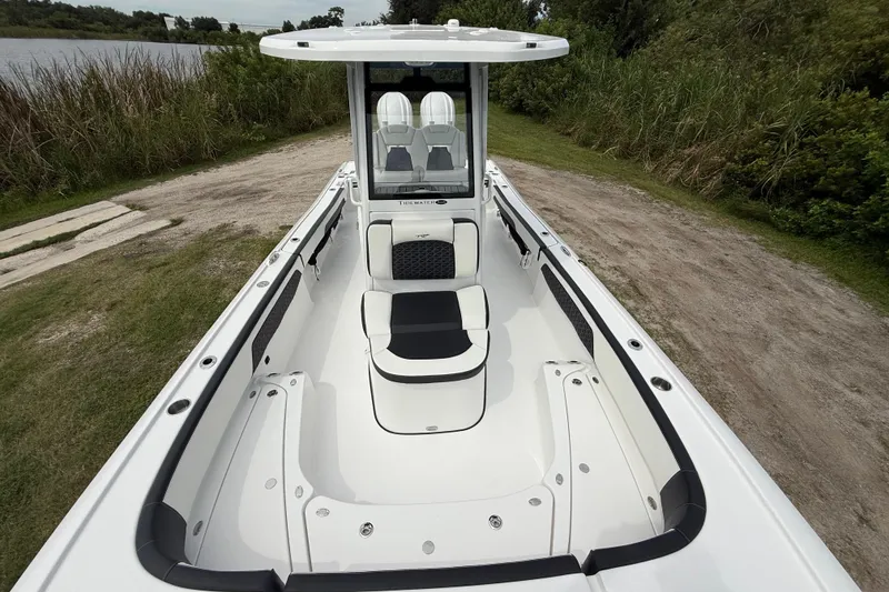 Slide: The Image of 2026 Tidewater 2700 Carolina Bay boat, sleek design, spacious deck, near lush greenery and water. - 22