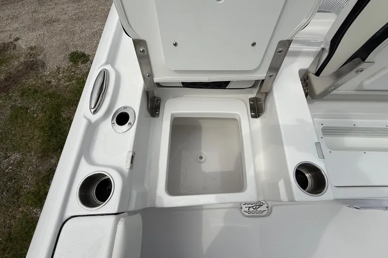 Slide: The Image of 2026 Tidewater 2700 Carolina Bay boat interior with open storage compartment and cup holders. - 28