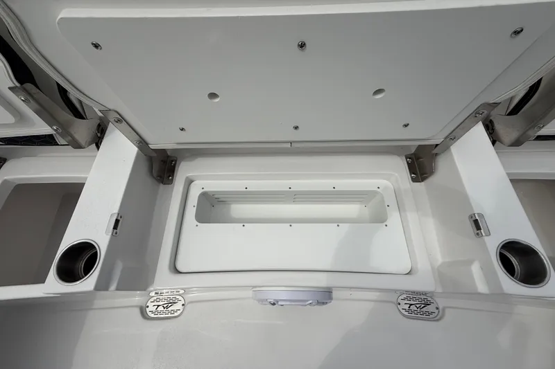 Slide: The Image of 2026 Tidewater 2700 Carolina Bay boat storage compartment with cup holders and stainless steel fittings. - 29