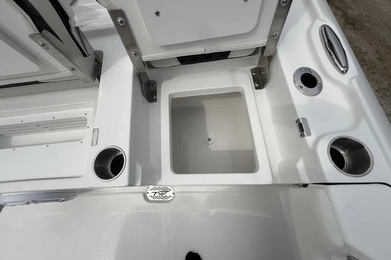 Slide: The Image of 2026 Tidewater 2700 Carolina Bay boat interior with storage compartment and cup holders. - 31