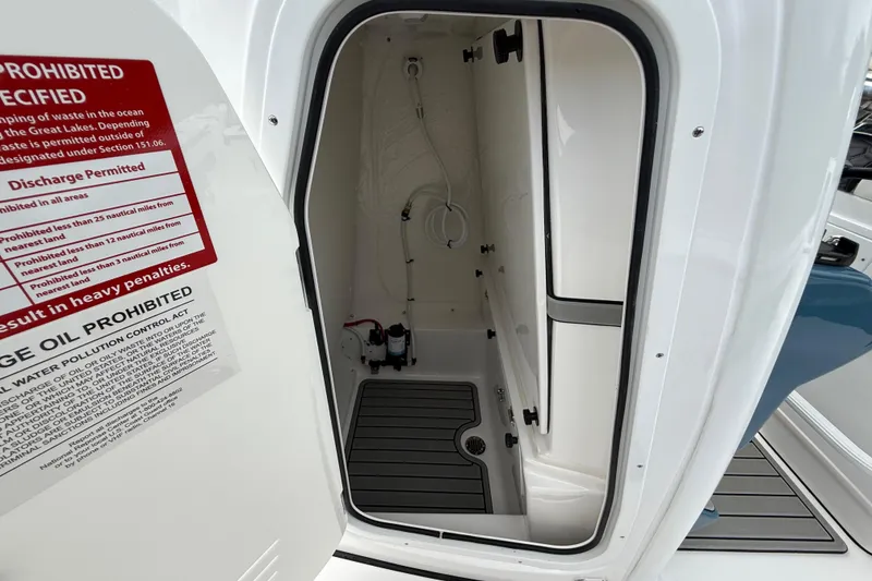 Slide: The Image of 2026 Tidewater 2700 Carolina Bay boat interior with open storage compartment and safety notice. - 41