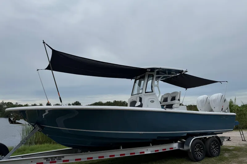 Slide: The Image of 2026 Tidewater 2700 Carolina Bay boat on trailer with dual engines and canopy. - 51
