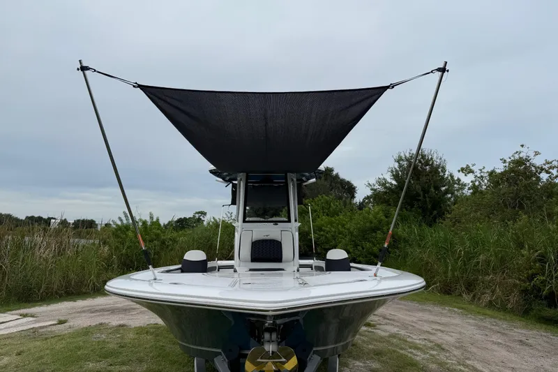 Slide: The Image of 2026 Tidewater 2700 Carolina Bay boat with canopy, parked on grassy area. - 52