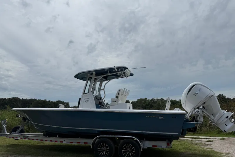Slide: The Image of 2026 Tidewater 2700 Carolina Bay boat on trailer under cloudy sky. - 8