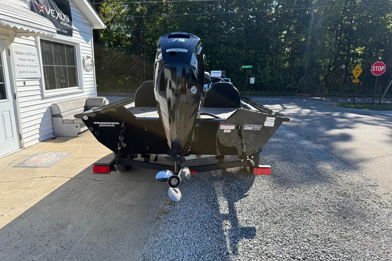 Slide: The Image of 2025 Tracker Pro Team 175 boat with Mercury engine parked outside a store. - 4