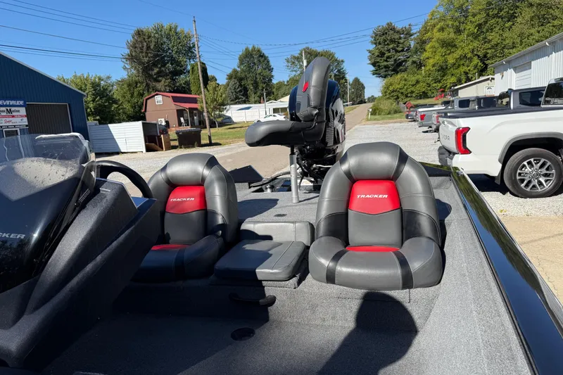 Slide: The Image of 2025 Tracker Pro Team 175 boat interior with black and red seats, parked outdoors. - 8
