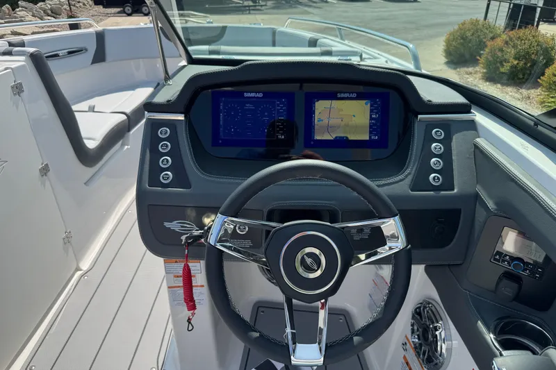 Slide: The Image of 2025 Chaparral 247 SSX boat dashboard with dual Simrad displays and sleek steering wheel. - 13