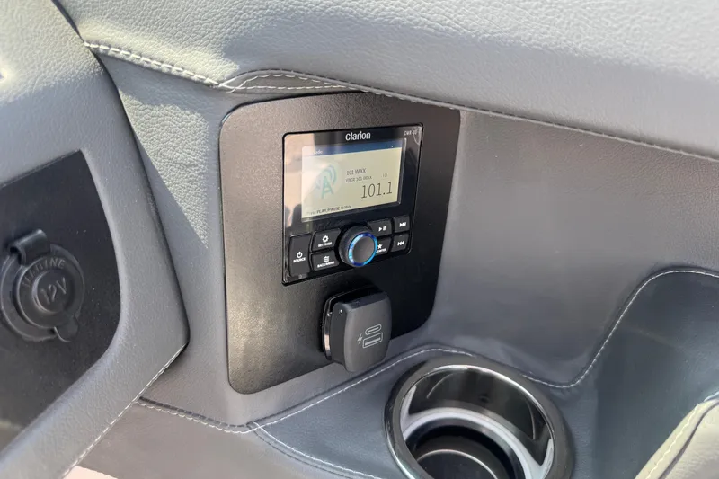 Slide: The Image of 2025 Chaparral 247 SSX dashboard with Clarion audio system and cup holder. - 15