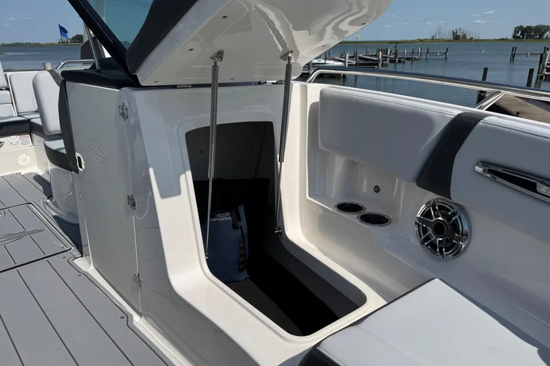 Slide: The Image of 2025 Chaparral 247 SSX boat interior with open storage compartment and speaker. - 25