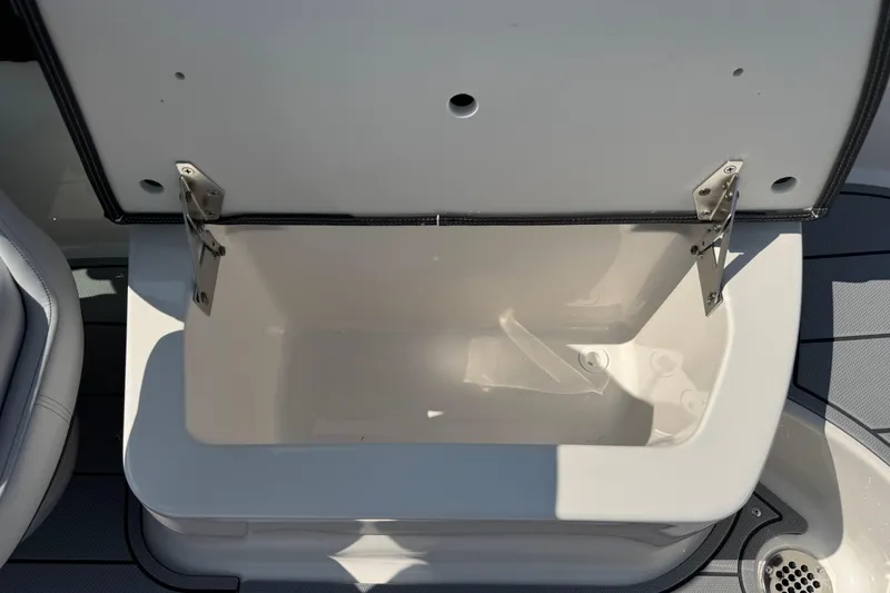 Slide: The Image of Open storage compartment on 2025 Chaparral 247 SSX boat, featuring stainless steel hinges. - 27