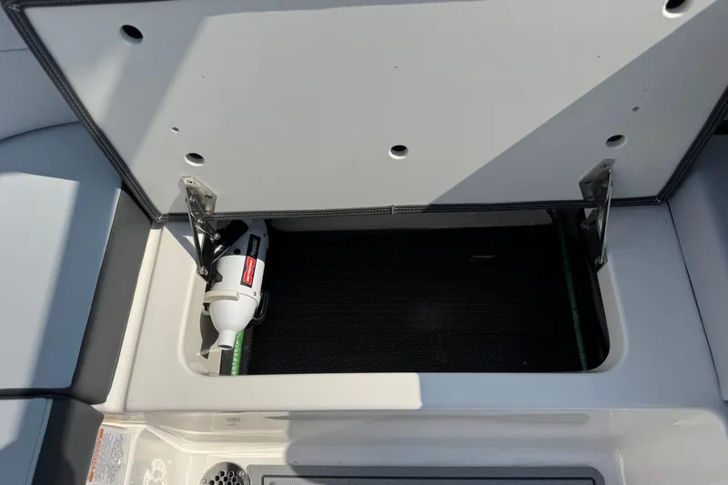 Slide: The Image of Open storage compartment in 2025 Chaparral 247 SSX boat, featuring a fire extinguisher. - 28