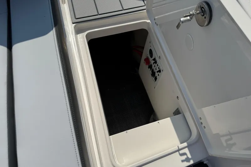 Slide: The Image of 2025 Chaparral 247 SSX boat storage compartment with control panel and key lock. - 29
