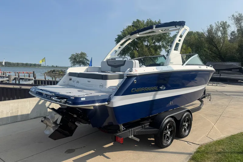 Slide: The Image of 2025 Chaparral 247 SSX boat on trailer by lakeside, showcasing sleek design and modern features. - 5