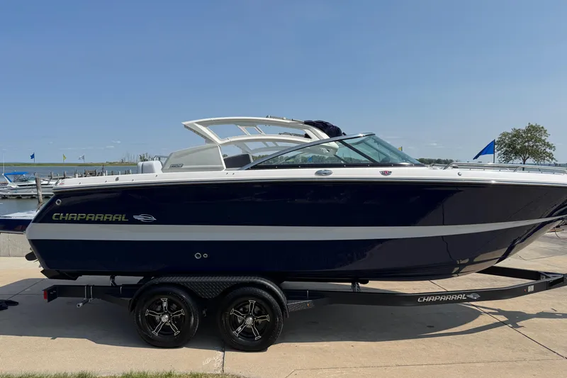 Slide: The Image of 2025 Chaparral 247 SSX boat on trailer, dockside with clear blue sky. - 8