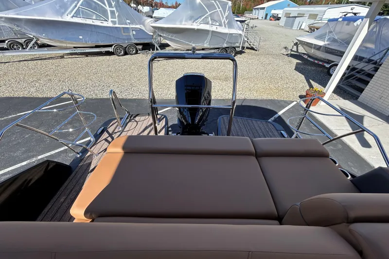 Slide: The Image of 2026 Harris FloteBote Cruiser 230 SL with tan seating and sleek design in a boatyard. - 13