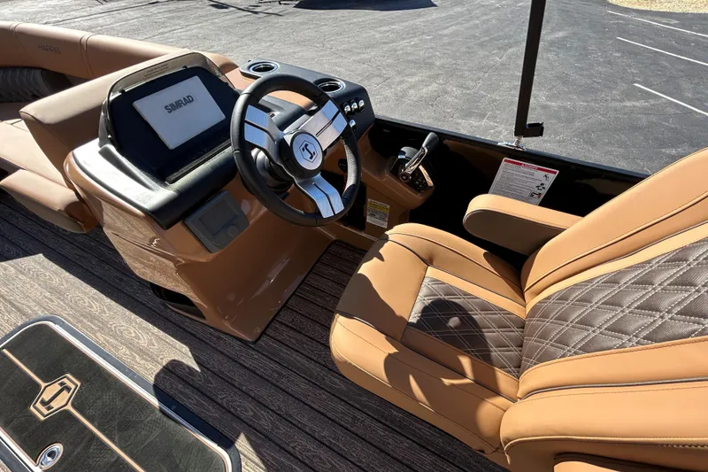 Slide: The Image of 2026 Harris FloteBote Cruiser 230 SL interior with luxurious tan seating and modern steering console. - 26