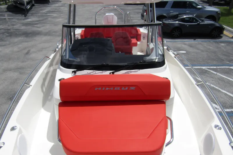 Slide: The Image of 2024 Nimbus T8 boat with red seating, parked in a lot. - 10