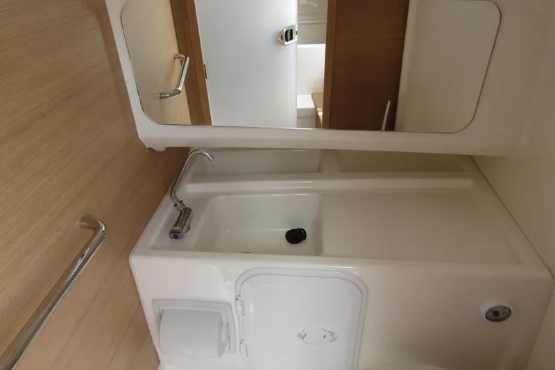 Slide: The Image of 2024 Nimbus T8 boat bathroom with sink, mirror, and wooden accents. - 24