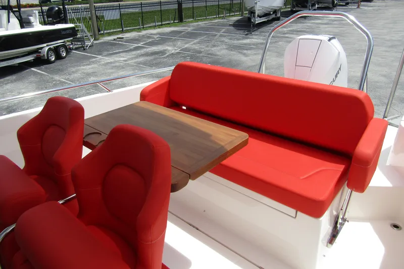 Slide: The Image of 2024 Nimbus T8 boat interior with red seating and wooden table. - 25