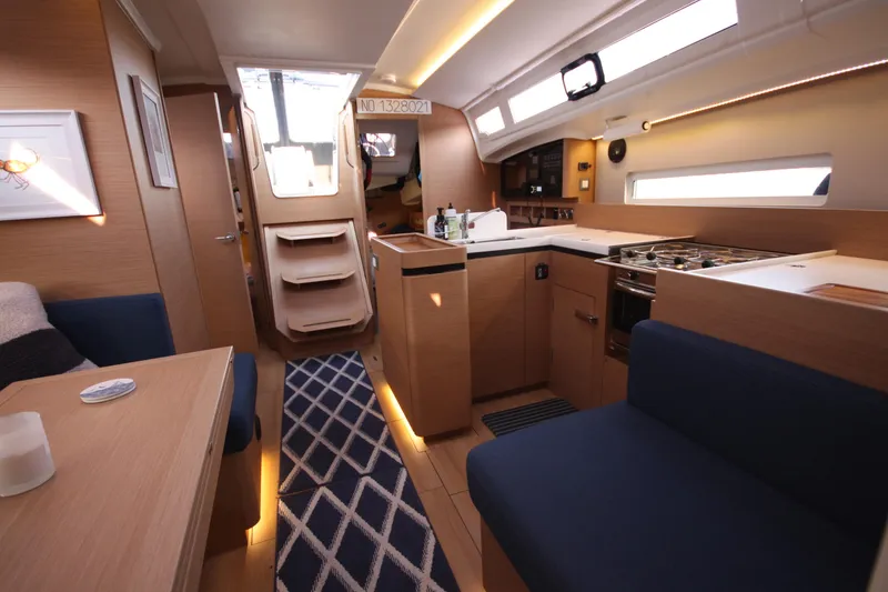 Slide: The Image of Interior of 2022 Jeanneau Sun Odyssey 410 yacht, featuring modern kitchen and seating area. - 12