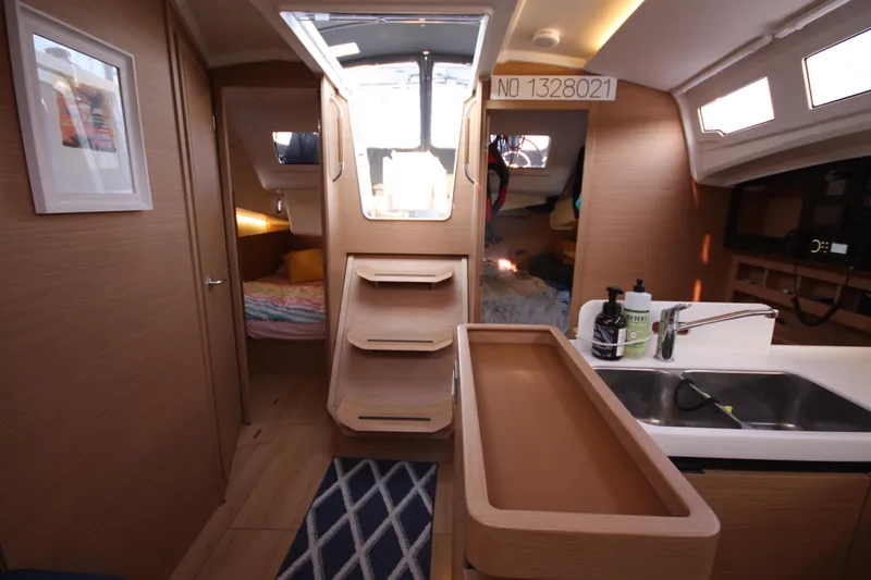 Slide: The Image of Interior of 2022 Jeanneau Sun Odyssey 410 yacht, featuring modern kitchen and cozy sleeping area. - 16