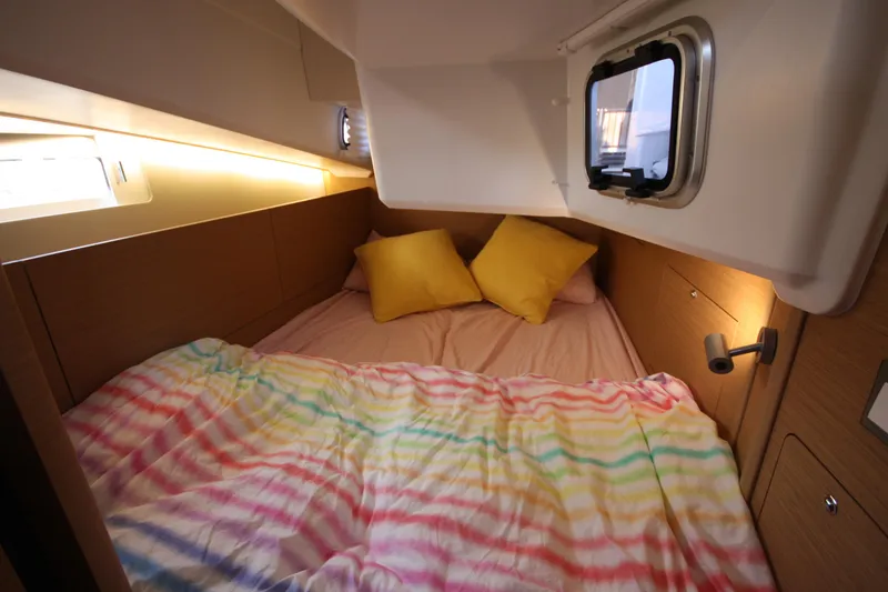 Slide: The Image of Cozy cabin interior of 2022 Jeanneau Sun Odyssey 410 with colorful bedding and yellow pillows. - 24