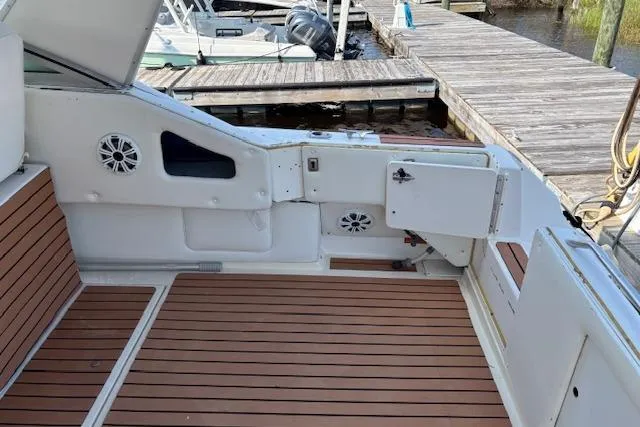 Slide: The Image of 1992 Sea Ray 330 Sundancer boat interior with wood flooring and dock view. - 11