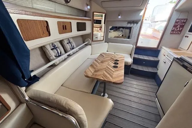 Slide: The Image of Interior of 1992 Sea Ray 330 Sundancer with cozy seating and wooden table. - 17