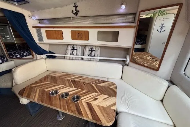 Slide: The Image of Interior of 1992 Sea Ray 330 Sundancer with wood table and white seating. - 19