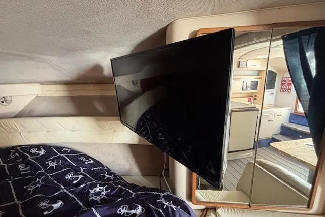 Slide: The Image of 1992 Sea Ray 330 Sundancer interior with mounted TV and nautical-themed bedding. - 24