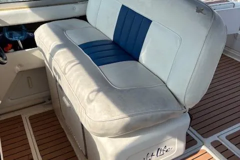 Slide: The Image of 1992 Sea Ray 330 Sundancer boat interior with cushioned seating and wood-style flooring. - 25