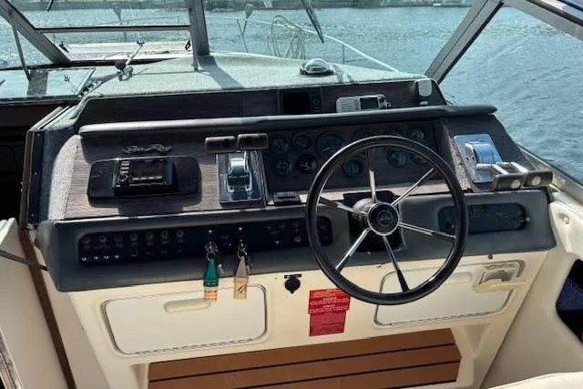 Slide: The Image of Cockpit of 1992 Sea Ray 330 Sundancer with steering wheel and control panel. - 26