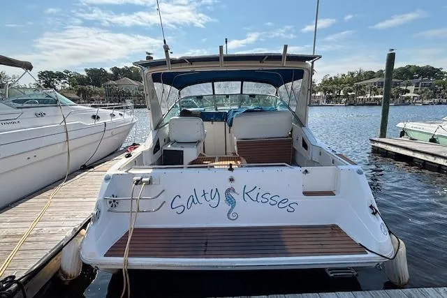 Slide: The Image of 1992 Sea Ray 330 Sundancer docked, named "Salty Kisses," with a seahorse design. - 3