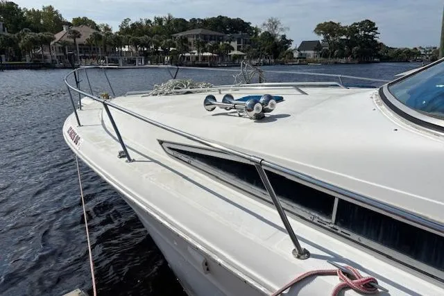 Slide: The Image of 1992 Sea Ray 330 Sundancer docked on a calm river with scenic background. - 5
