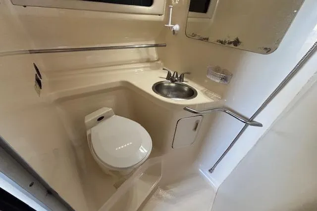 Slide: The Image of 1992 Sea Ray 330 Sundancer bathroom with toilet, sink, and mirror. - 7