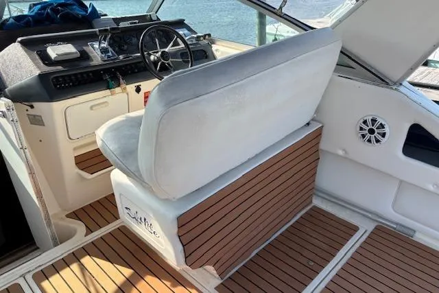 Slide: The Image of 1992 Sea Ray 330 Sundancer cockpit with helm, cushioned seating, and wood accents. - 9