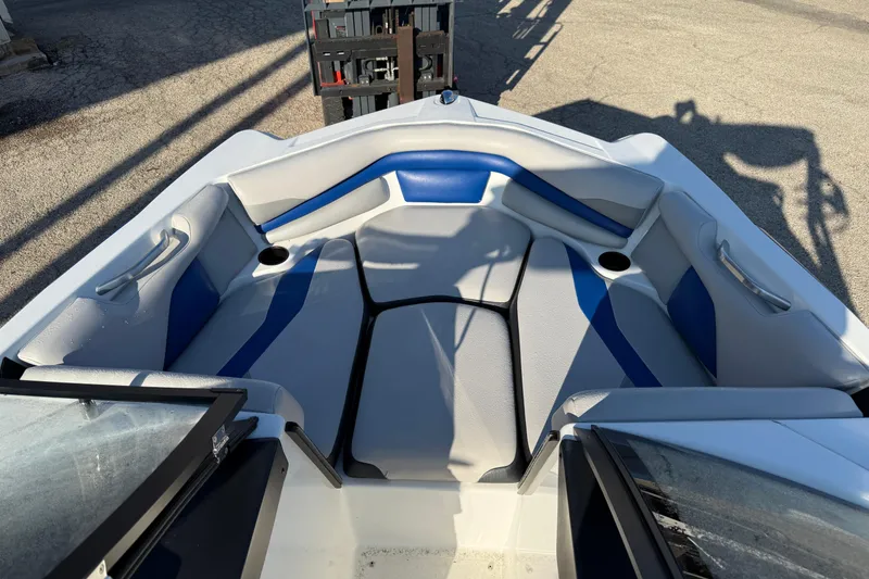Slide: The Image of 2018 Axis A20 boat interior with blue and gray seating, cup holders, and open windshield. - 11